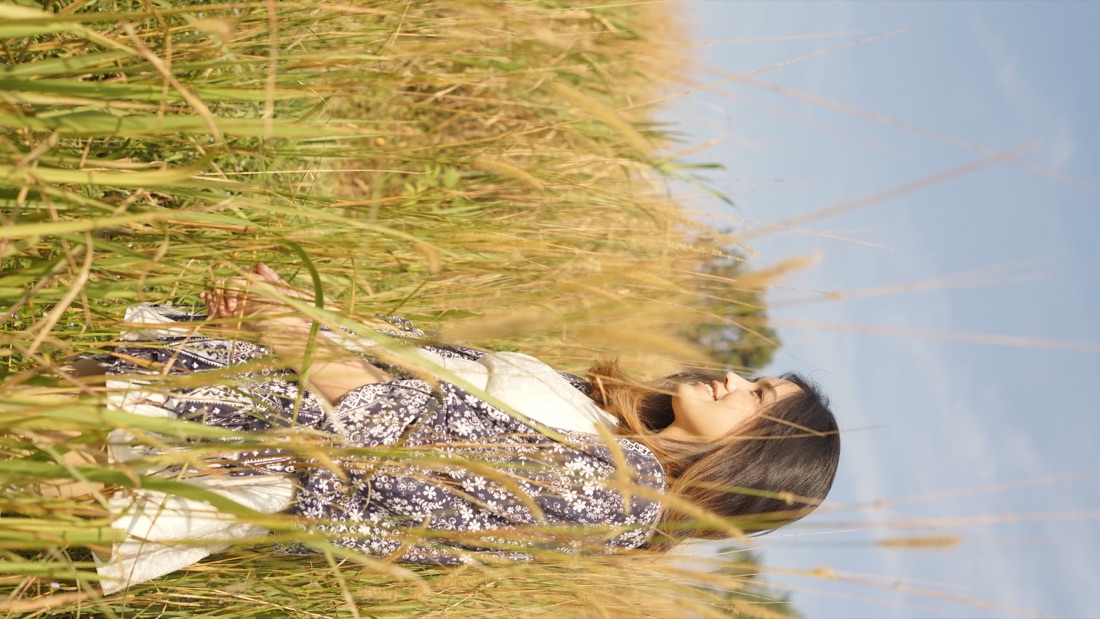 Filananda standing in a golden grass field